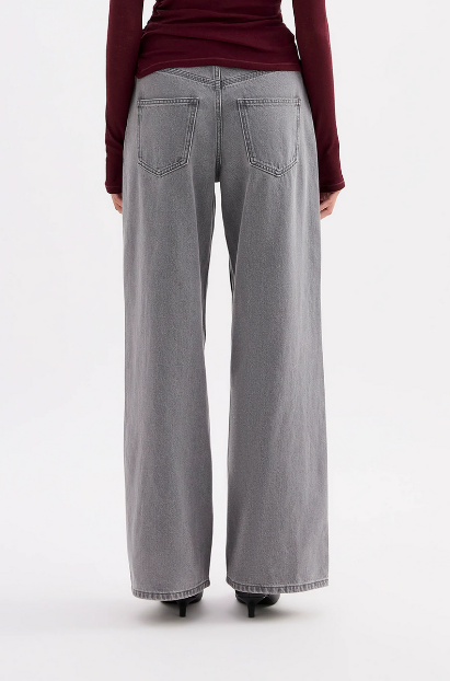 A back view shows the Steel boyfriend jeans with rear patch pockets and a relaxed wide-leg fit.
