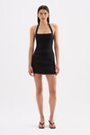 A model wears the black skort with a fitted black top, showing the mini skirt appearance from the front.
