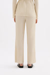 Back view of the cream full-length pants showing the relaxed straight-leg shape.