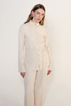 Product-only front view of the cream long sleeve shirt with traditional collar, shell buttons and waist tie.