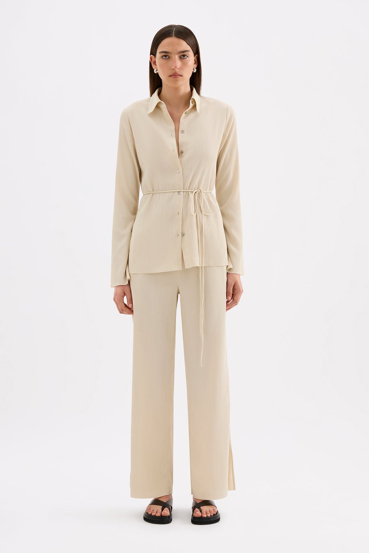 Front view of the cream shirt styled with matching pants, showing the button opening and tied waist.