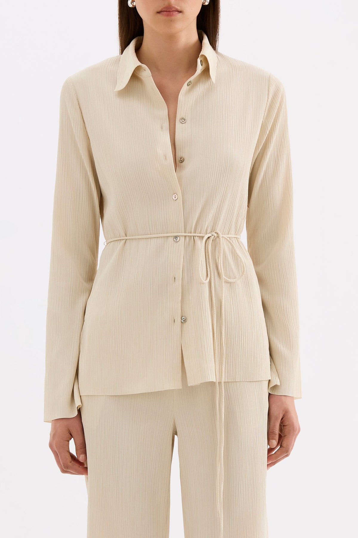 Close-up front view highlighting the traditional collar, shell buttons and gathered waist tie.