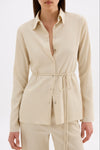 Front view of the cream shirt styled with matching pants, showing the button opening and tied waist.