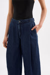 Close-up front view of the indigo blue denim pants showing the button fastening, waistband, front pleats and side pocket.