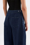Close-up back view of the indigo blue denim pants showing the adjustable waist tab, back pocket and waistband details.