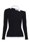 Product-only front view showing the black fitted long sleeve top with asymmetrical neckline and white contrast halter layer.