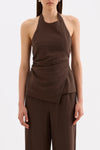 Front close-up showing the high halter neckline, fitted waist and asymmetrical hem styled with matching chocolate pants.