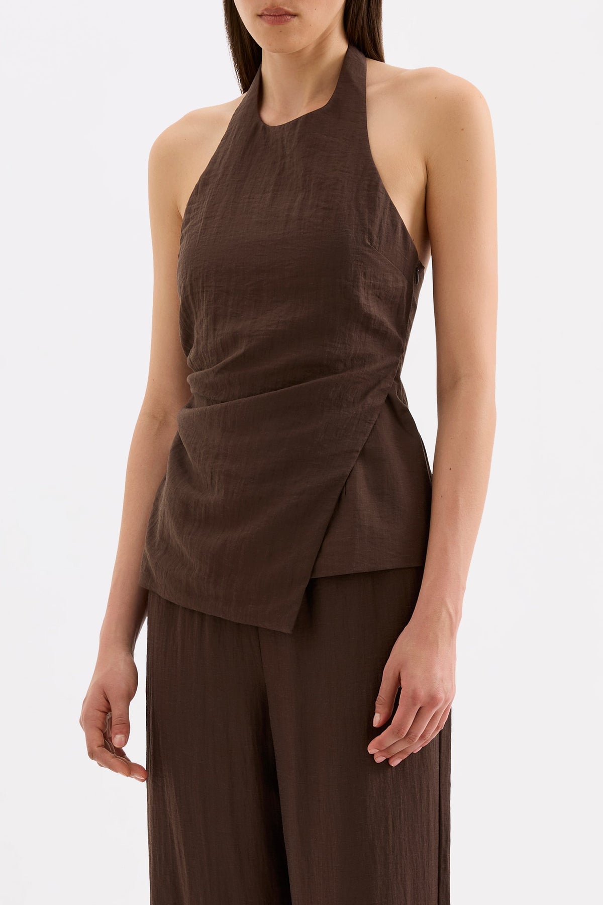 Three-quarter front view highlighting the gathered waist and asymmetric hem of the chocolate halter top.