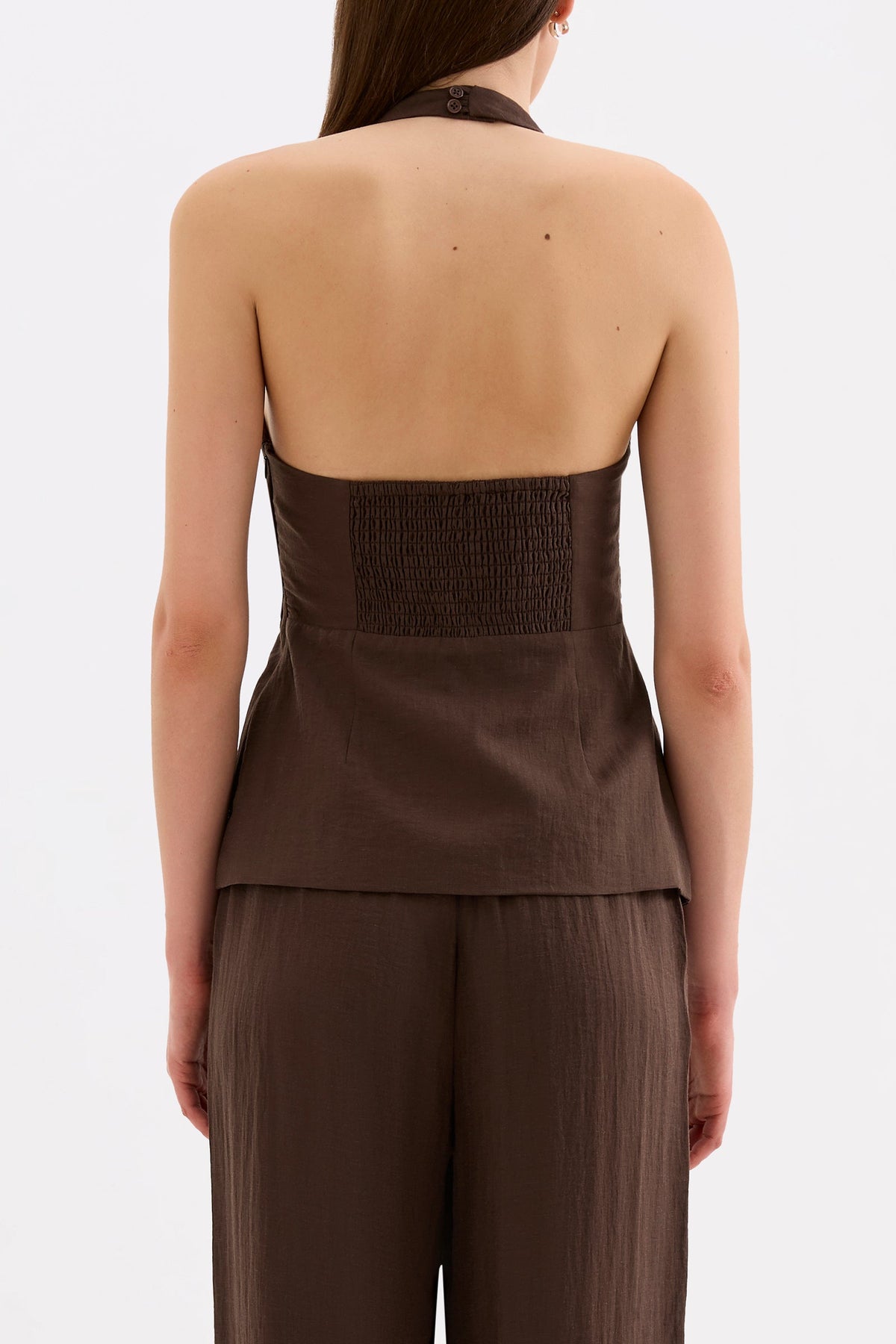 Back view showing the halter shape, shirred back panel and hip-length silhouette with matching pants.
