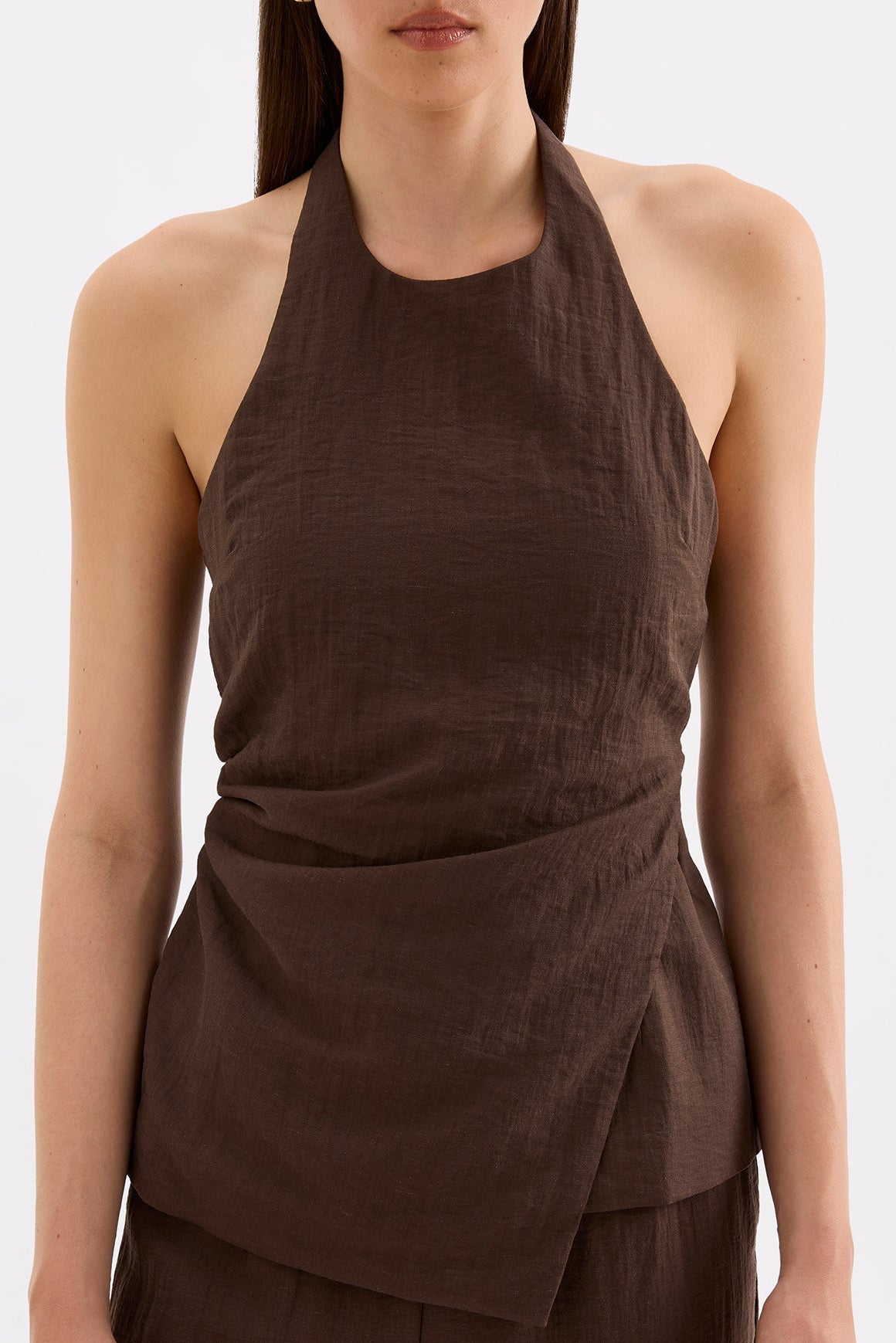 Close-up front view showing the high neckline, sleeveless cut and gathered detailing through the waist.