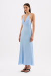 The model wears the Bermuda blue maxi dress in a three-quarter side view, showing the bias-cut shape and flowing skirt.