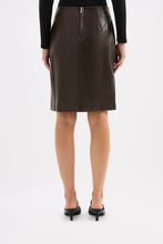 Brown leather skirt worn by a person on a white background