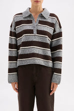 Person wearing a striped sweater with a plain background