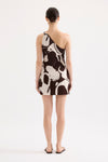 A back view shows the asymmetric one-shoulder design and abstract Ombra Print of the Nude Lucy mini dress.
