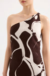 A close-up shows the one-shoulder neckline and brown and cream Ombra Print of the Nude Lucy mini dress.
