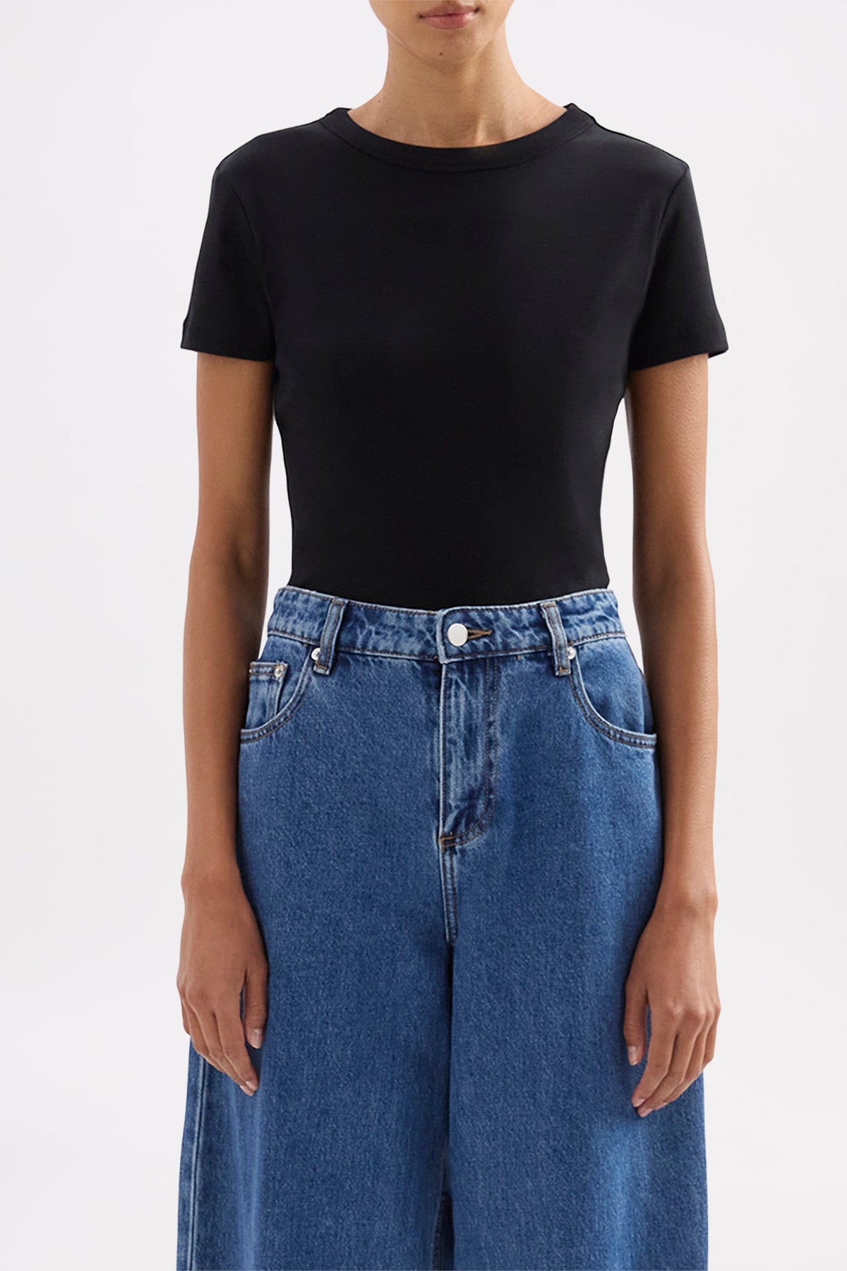 Front close-up showing the fitted silhouette, short sleeves and crew neckline styled with blue denim.