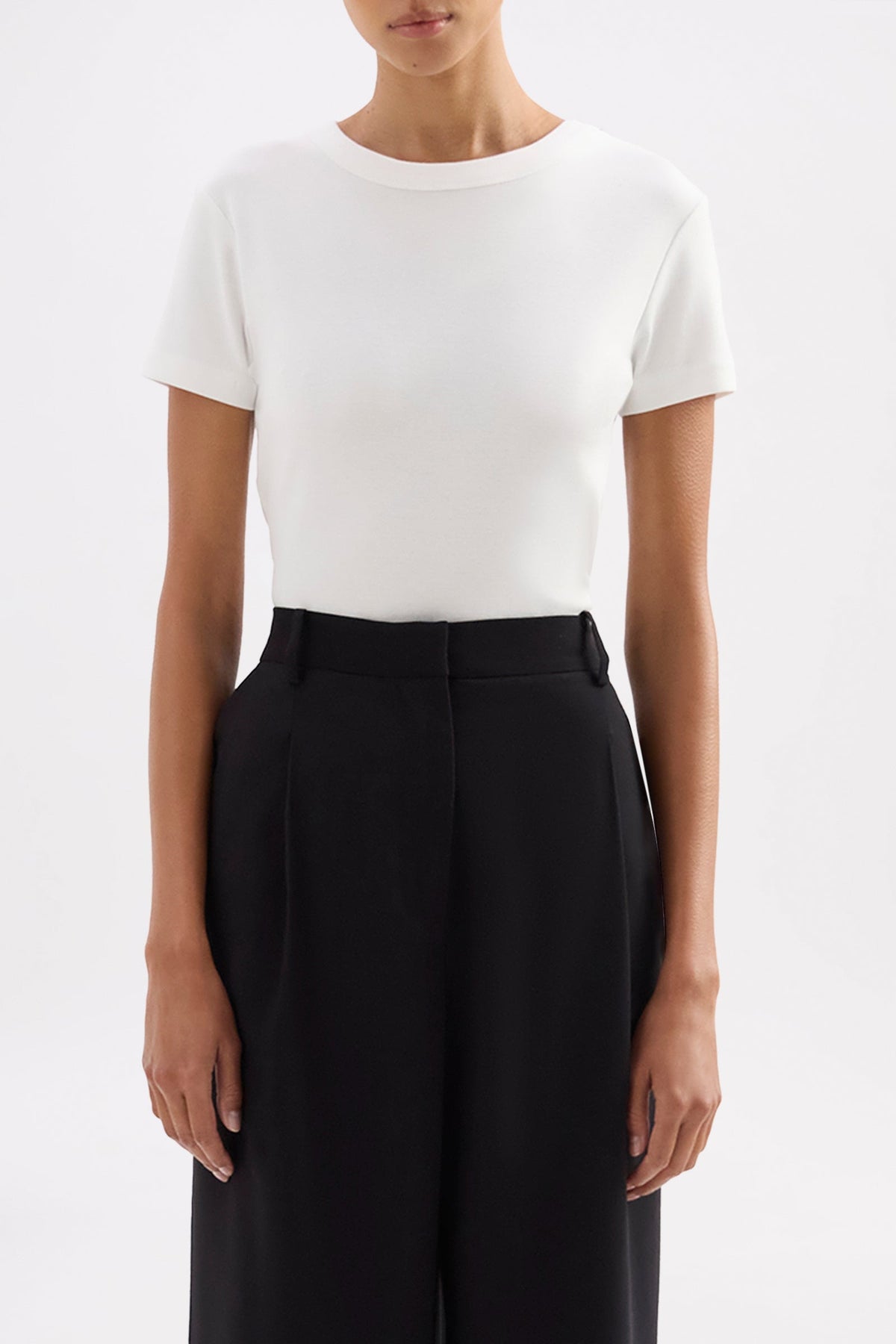 Close-up front view showing the white fitted tee with crew neckline and short cap sleeves.