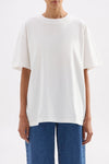 Front close-up showing the relaxed boxy fit, crew neckline and short sleeves of the white tee.