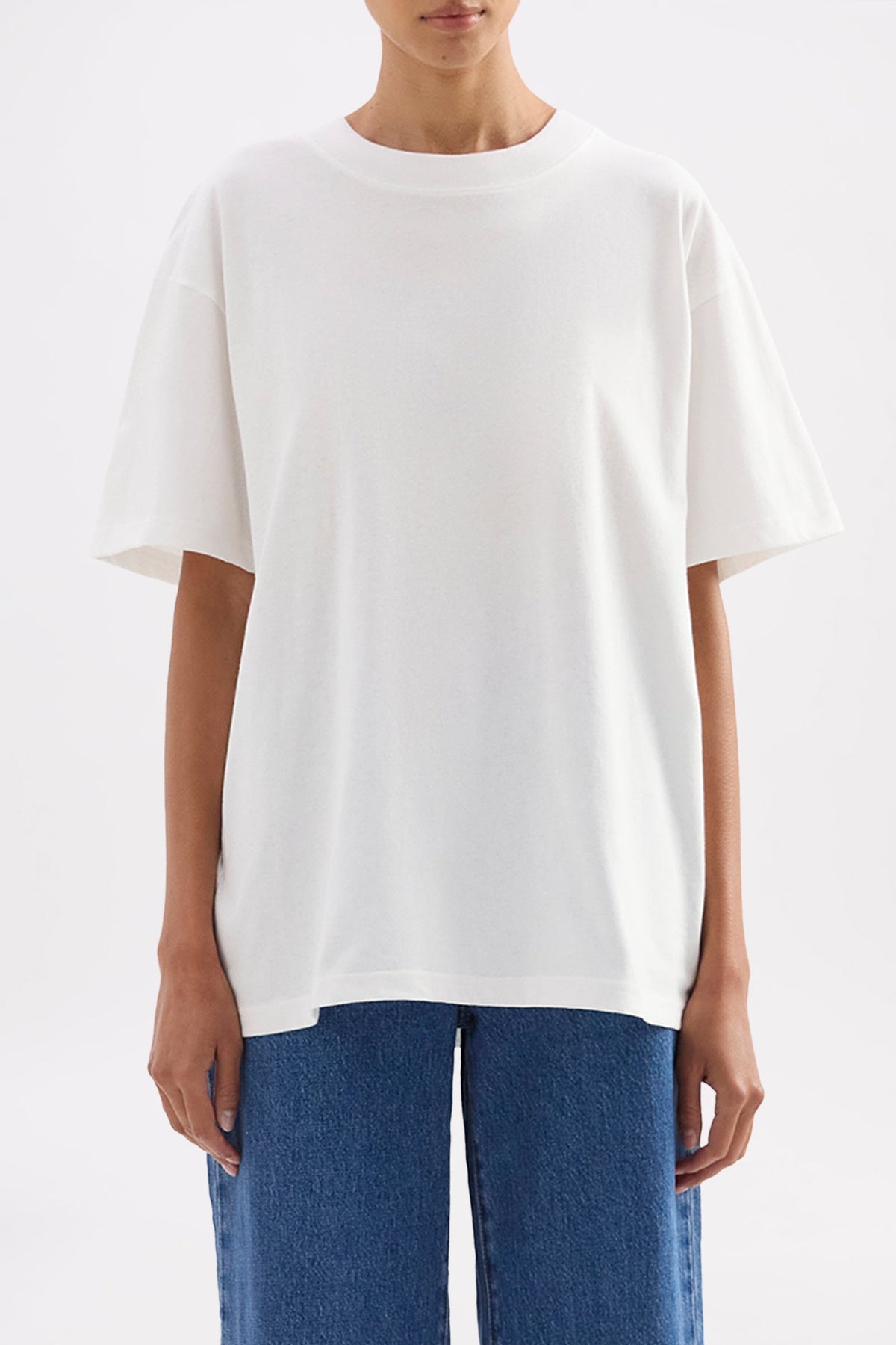 Front close-up showing the relaxed boxy fit, crew neckline and short sleeves of the white tee.
