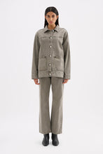 Full-length front view of the stone grey denim jacket styled with matching relaxed jeans and black ankle boots.