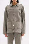 Close front view showing the collared neckline, button closure, chest seam and front patch pockets.