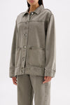Three-quarter view highlighting the boxy silhouette, long sleeves and stone-washed denim finish.