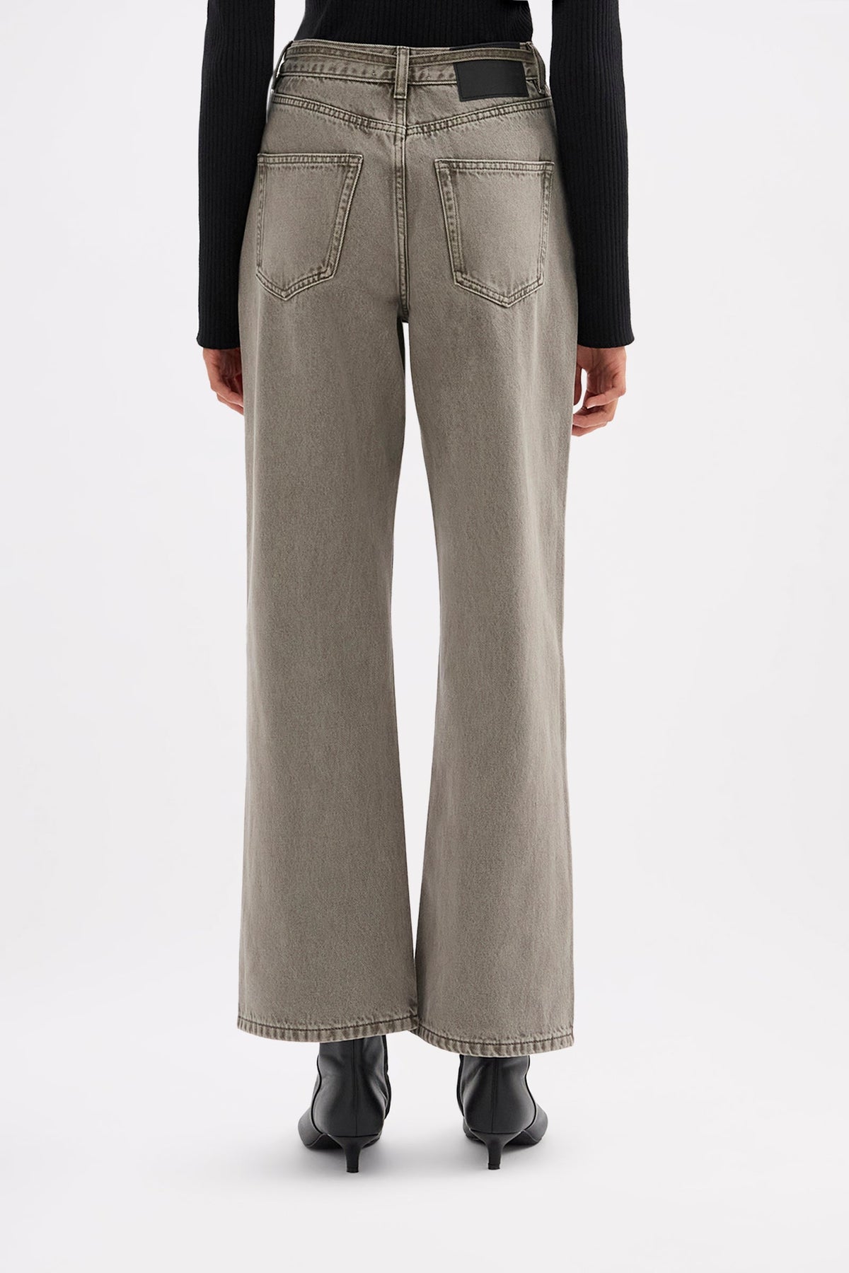 Back view of the stone grey jeans showing the rear pockets, relaxed leg and jacron patch at the waistband.