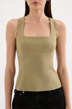 A close-up front view shows the moss Thea Top styled with black jeans, highlighting the square neckline and fitted waist.
