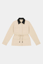 Beige Idris Jacket laid flat on a white background, showing the black contrast collar, long sleeves, front closure, patch pockets and detachable waist tie