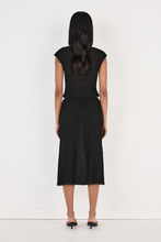 Model wearing the black Rita Top with the matching midi skirt, showing the fitted back, cap sleeves, cropped hem and lightweight crinkled texture in a full-length back view.
