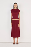 Model wearing the crimson Rita Top with the matching midi skirt and strappy heels, showing the high rounded neckline, cap sleeves, fitted cropped silhouette and softly crinkled texture in a full-length front view.
