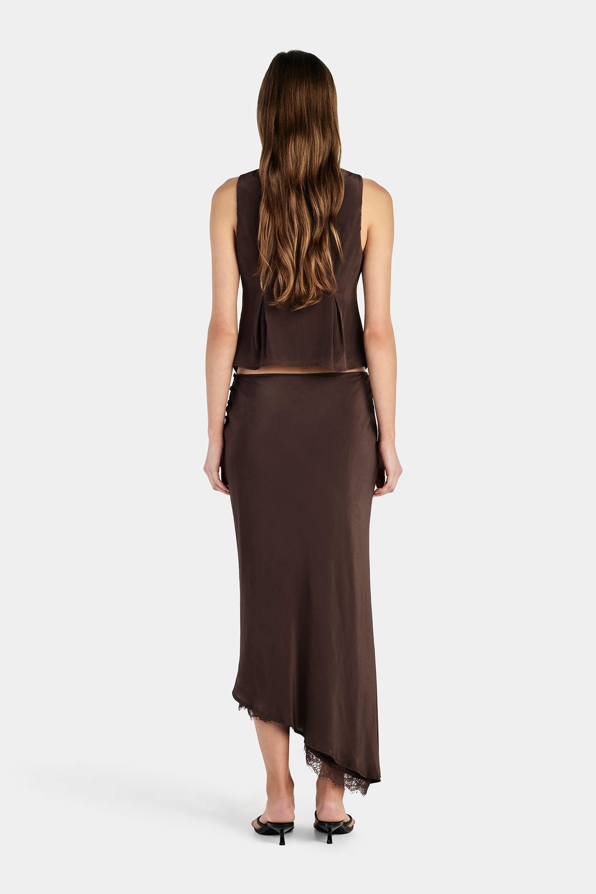 A back view shows the chocolate brown sleeveless top with a fitted shape and softly flared hem.
