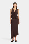 A woman wears a chocolate brown lace-trim sleeveless top with a matching skirt in a full-length front view.