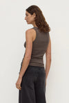 Model wearing the bark rib tank with washed black jeans, showing the fitted shape, sleeveless cut and clean scoop-back silhouette, back angled view
