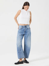 Model wearing the Rolla's Arc Barrel Jean in Lennon Vintage with a white cropped tank and black loafers, showing the relaxed barrel-leg silhouette, full-length front view
