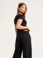 Close-up back view of the washed black jeans, showing the back yoke, square patch pockets, matching black stitching and relaxed seat.