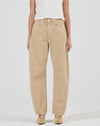 A model wears the Rolla’s Arc Barrel Long Jean in Dune with a white fitted top in a front studio view.
