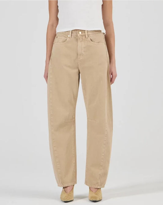 A model wears the Rolla’s Arc Barrel Long Jean in Dune with a white fitted top in a front studio view.
