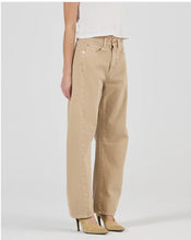 A model wears the dune barrel-leg jeans in an angled side view showing the curved silhouette and knee darts.
