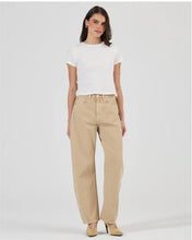 A model wears the dune mid-rise barrel jeans with a white T-shirt in a full-length front studio view.
