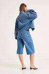 Back view of mid-blue denim culottes showing the square back pockets, waistband and contrast stitching.