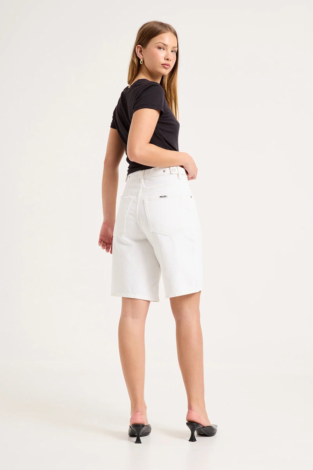Back view of white knee-length denim shorts showing the waistband, square back pockets and relaxed silhouette.