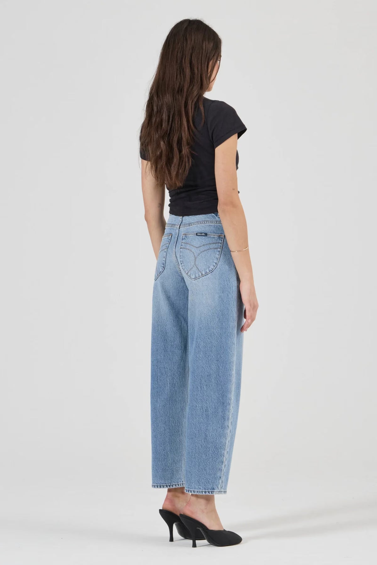 Rear view of light blue barrel jeans showing the fitted high-rise waistband, curved back yoke, signature spade-shaped back pockets with contrast stitching and relaxed legs that narrow towards the hems.