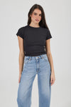 Close-up of light blue high-rise jeans showing the waistband, metal button, zip-fly area, belt loops, front scoop pockets and small coin pocket, paired with a fitted black crew-neck tee.