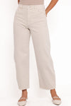 Close-up front view of off-white high-rise barrel jeans showing the waistband, silver button closure, belt loops, front scoop pockets and wide legs paired with beige ballet flats.