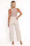 Rear view of off-white barrel jeans showing the high-rise waistband, curved yoke, signature spade-shaped back pockets and relaxed legs, styled with a beige sleeveless top and strappy heels.
