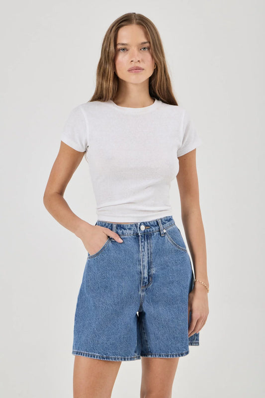 Blue denim shorts shown from the front with a super high-rise waist, scoop pockets and mid-thigh length.