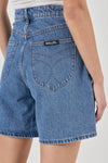 Close-up back view of blue denim shorts showing the shaped back pockets, contrasting stitching and waistband.