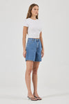 Blue denim shorts shown from a three-quarter side view, highlighting the high-rise waist, scoop pocket and relaxed silhouette.