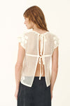 A back view shows the bone crochet top with an open back and double tie detailing.
